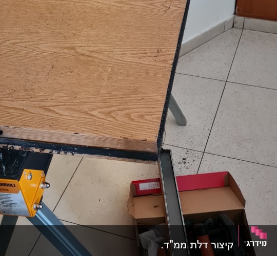 שולחן עבודה עם מסור חשמלי וקרש עץ